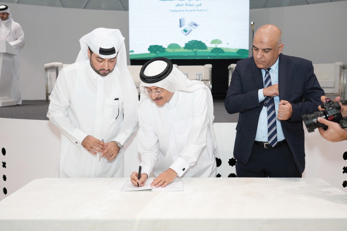 Deputy Chairperson of the NHRC, Dr. Mohammad bin Saif Al Kuwari signs a copy of the book.