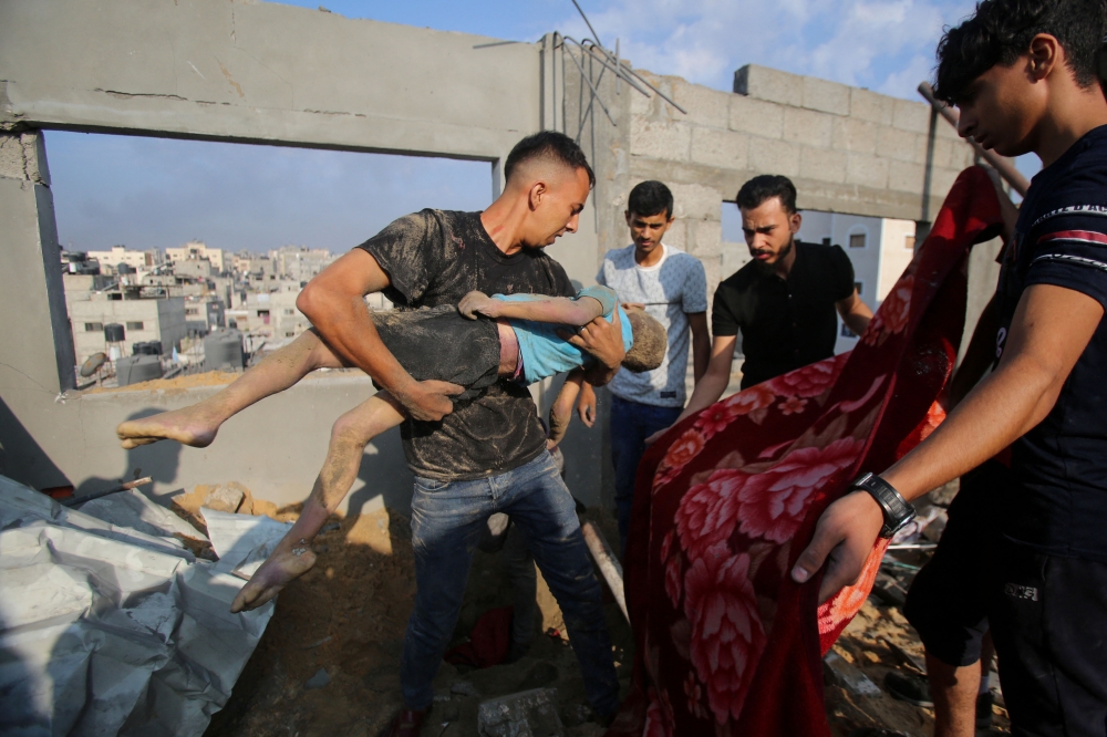 Palestinians carry the body of a victim in the aftermath of an Israeli strike in the Jabalia camp, on November 1, 2023. Photo by Bashar TALEB / AFP