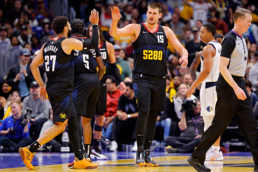 Jamal Murray #27 of the Denver Nuggets high fives Nikola Jokic #15 of the Denver Nuggets during the fourth quarter against the Dallas Mavericks. Photo by C. Morgan Engel/Getty Images/AFP 