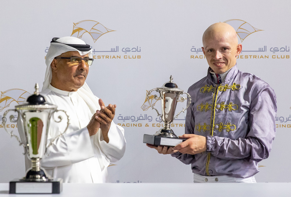 Jockey Olivier d’Andigne receives his trophy from QREC Racing Manager Abdulla Rashid Al Kubaisi.