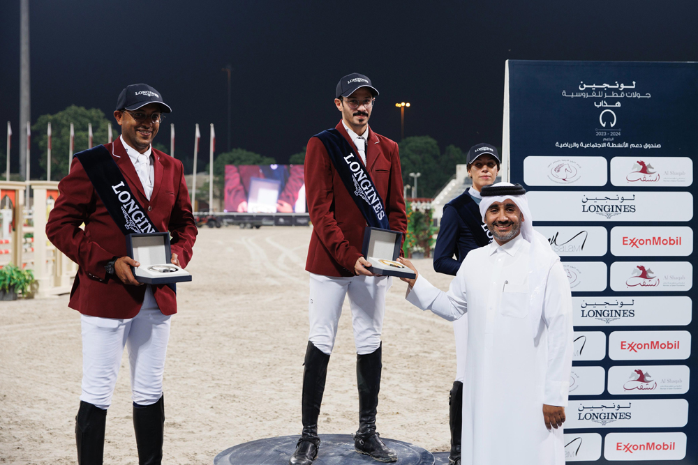 Longines Hathab Championship Deputy Event Director Faisal Al Kahla presents the Big Tour winner's trophy to Hamad Nasser Al Qadi. Bassem Hassan Mohammed (left) and Cyrine Cherif, who finished second and third respectively, are also present.