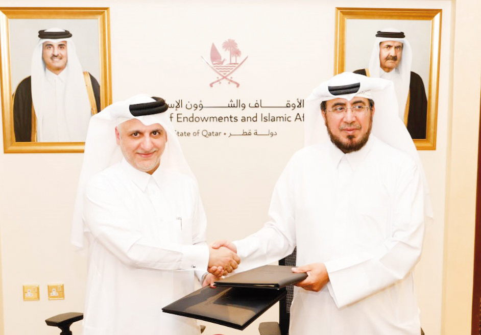 Assistant Undersecretary for Dawah and Mosque Affairs, Mohammed bin Hamad Al Kuwari and CCQ President Dr. Khalid Mohamed Al Horr (left) exchanging documents after signing an agreement yesterday.