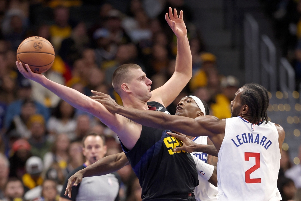 Nikola Jokic #15 of the Denver Nuggets is guarded by Terance Mann #14 and Kawhi Leonard #2 of the Los Angeles Clippers in the third quarter at Ball Arena on November 14, 2023 in Denver, Colorado. Matthew Stockman/Getty Images/AFP 