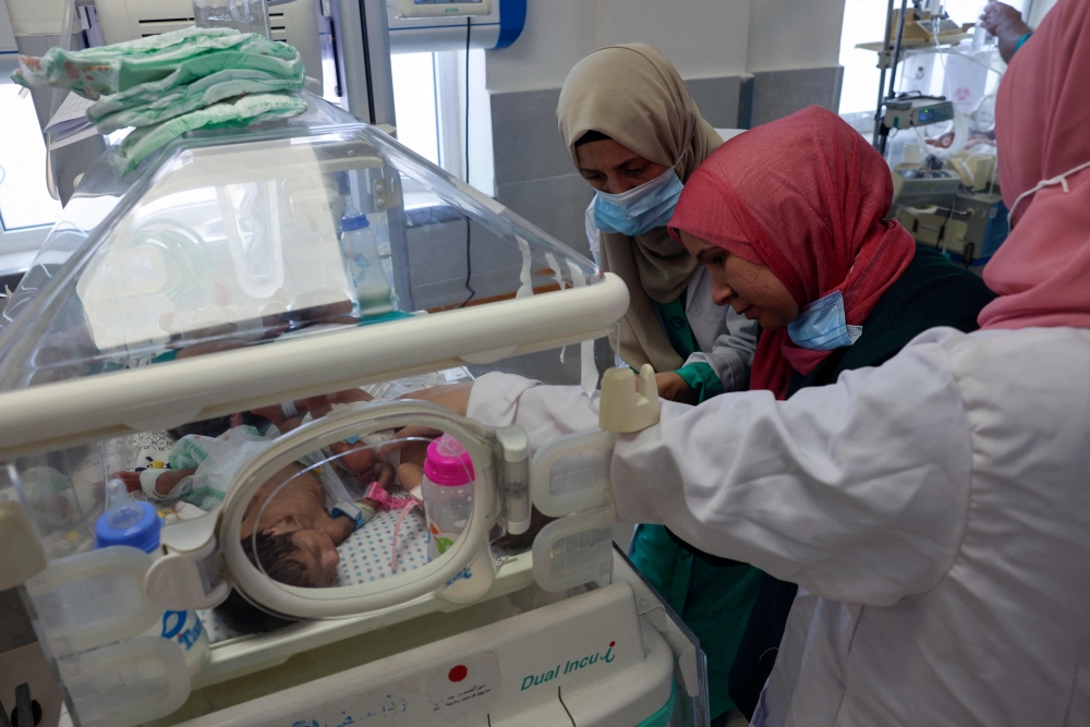 Palestinian medics care for premature babies evacuated from Al-Shifa Hospital to the Emirates hospital in Rafah in the southern Gaza Strip, on November 19, 2023. (Photo by Mohammed Abed / AFP)