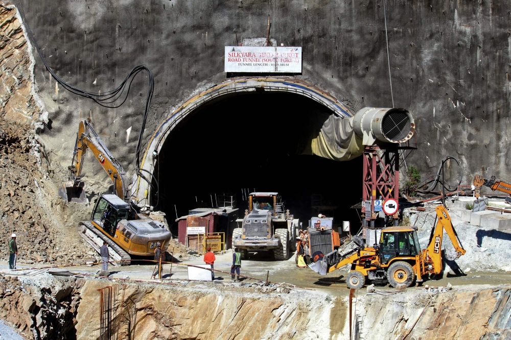 Rescue workers stand at an entrance of the under construction road tunnel, days after it collapsed in the Uttarkashi district of India's Uttarakhand state on November 18, 2023. Photo by AFP

