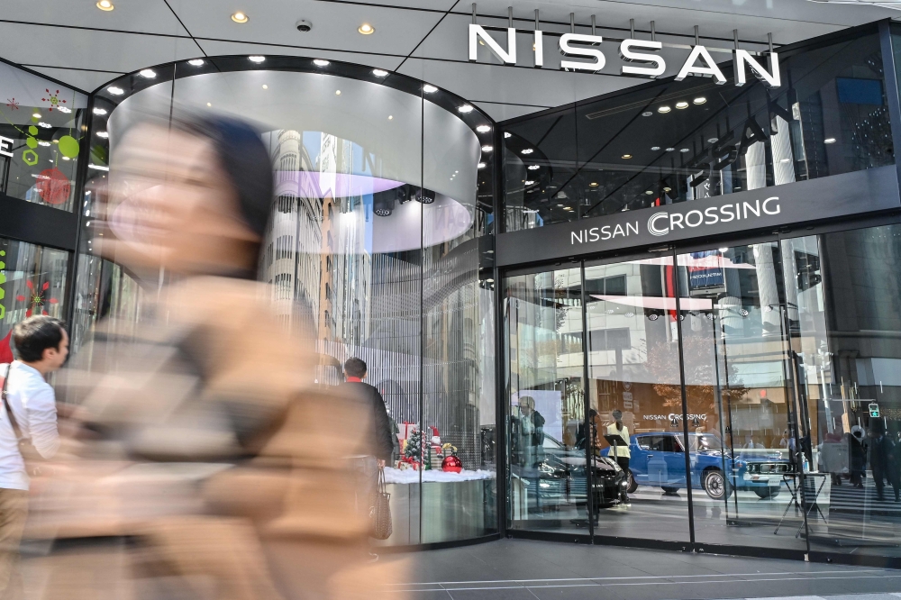 A pedestrian walks past the Nissan Crossing showroom in the Ginza area of central Tokyo on November 24, 2023. Photo by Richard A. Brooks / AFP