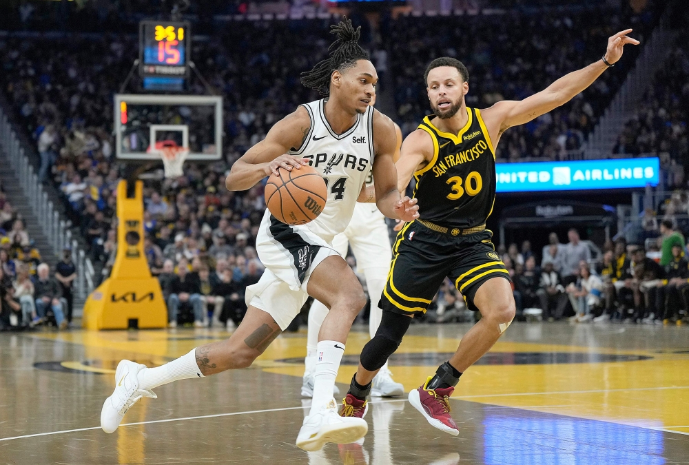 Devin Vassell #24 of the San Antonio Spurs drives against Stephen Curry #30 of the Golden State Warriors during the first quarter of the NBA In-Season Tournament game. Thearon W. Henderson/Getty Images/AFP 