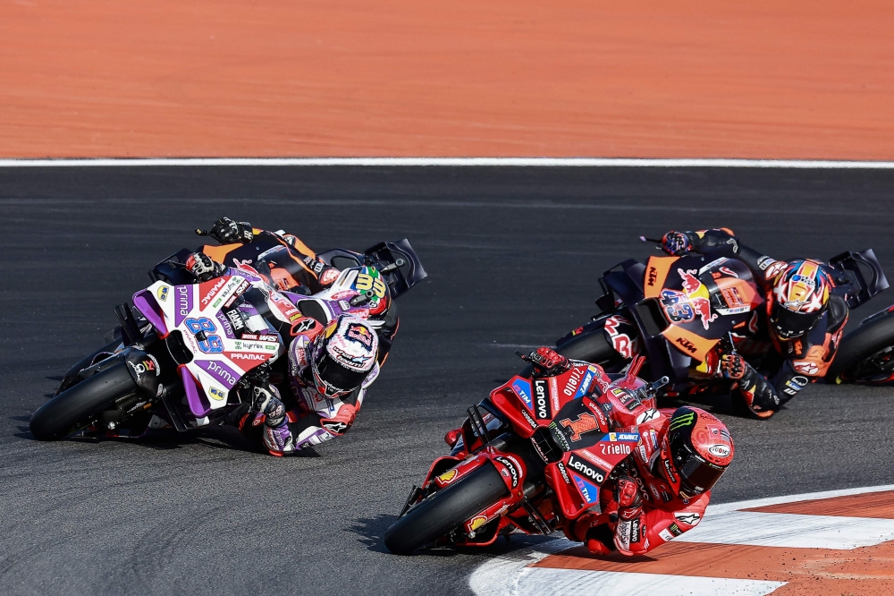 Ducati Italian rider Francesco Bagnaia drives ahead of Ducati Spanish rider Jorge Martin, KTM South African rider Brad Binder and KTM Australian rider Jack Miller during the MotoGP Valencia Grand Prix at the Ricardo Tormo racetrack in Cheste, on November 26, 2023. (Photo by JOSE JORDAN / AFP)
