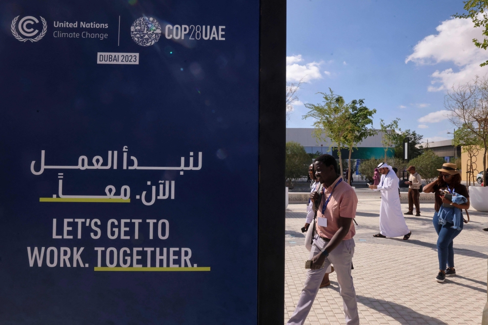 People arrive at the venue of the COP28 United Nations climate summit in Dubai on November 30, 2023. (Photo by Karim Sahib / AFP)
