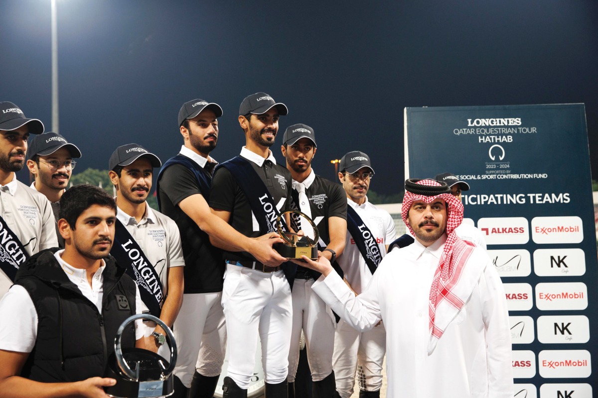 Team NK Cafe members Hussain Saeed Haidan, Ghanim Nasser Al Qadi and Saeed Nasser Al Qadi receive their trophy during the podium ceremony.