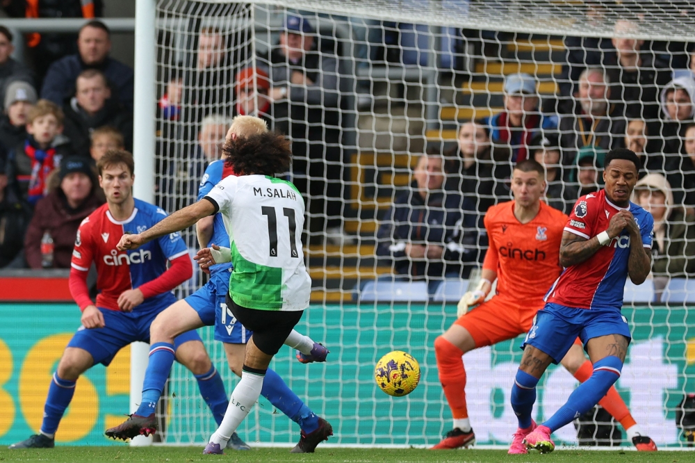 Liverpool's Egyptian striker #11 Mohamed Salah (C) shoots to score their first goal during the English Premier League football match between Crystal Palace and Liverpool at Selhurst Park in south London on December 9, 2023. (Photo by Adrian DENNIS / AFP)