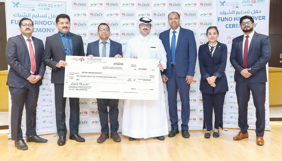 Regional Manager of Lulu Hypermarket Shanavas P presenting the donation cheque to Public Relations Officer of Qatar Cancer Society, Ammar Al Mashhadani.