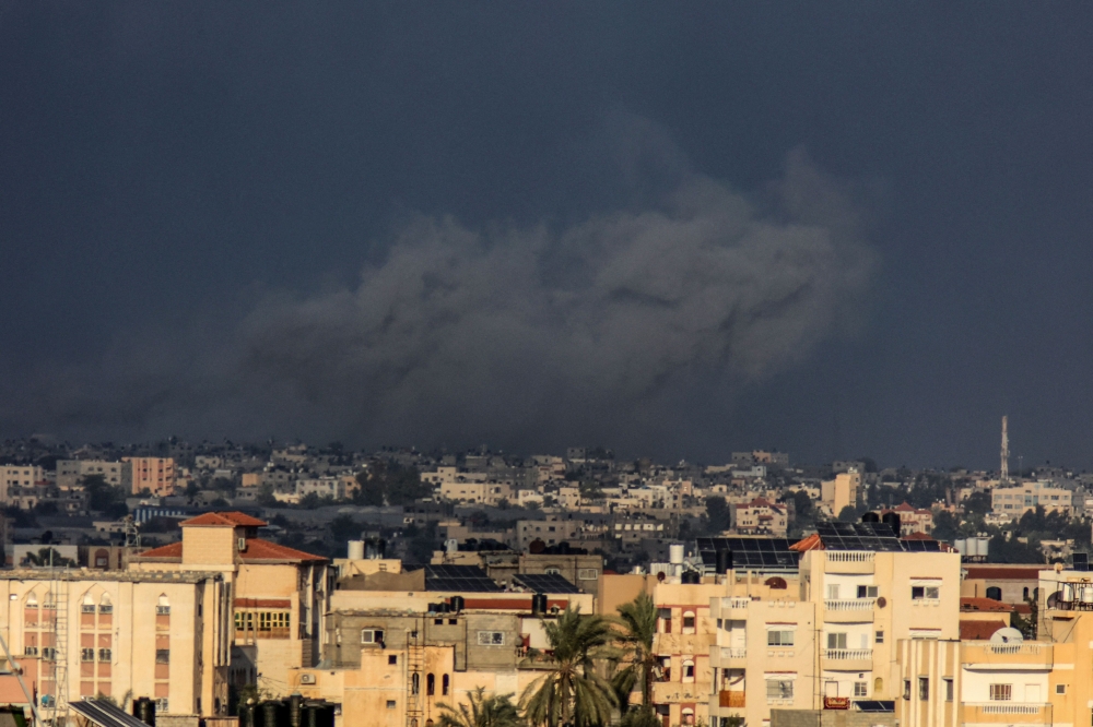 A picture taken from Rafah shows smoke billowing over Khan Yunis during Israeli bombardment in the southern Gaza Strip on December 24, 2023. (Photo by Said Khatib / AFP)