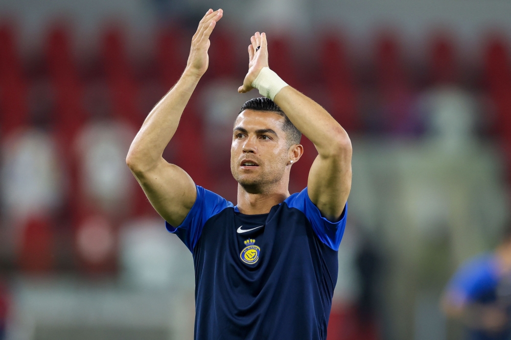 Nassr's Portuguese forward #07 Cristiano Ronaldo greets the fans ahead of the Saudi Pro League football match between Al-Ittihad and Al-Nassr at King Abdullah Sports City Stadium in Jeddah on December 26, 2023. (Photo by AFP)