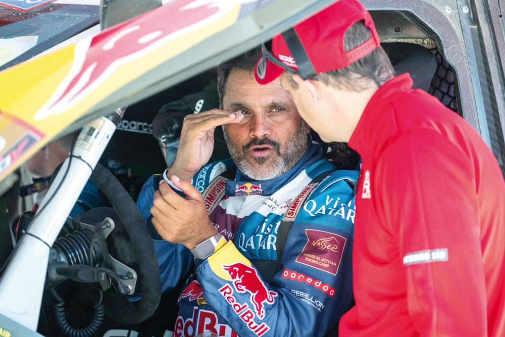 Prodrive’s Qatari driver Nasser Al Attiyah talks with a technician ahead of the Dakar 2024 in Al Ula, Saudi Arabia. AFP