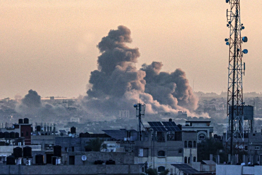 A picture taken from Rafah shows smoke billowing over Khan Yunis in the southern Gaza Strip during Israeli bombardment on January 14, 2024 (Photo by AFP)
 