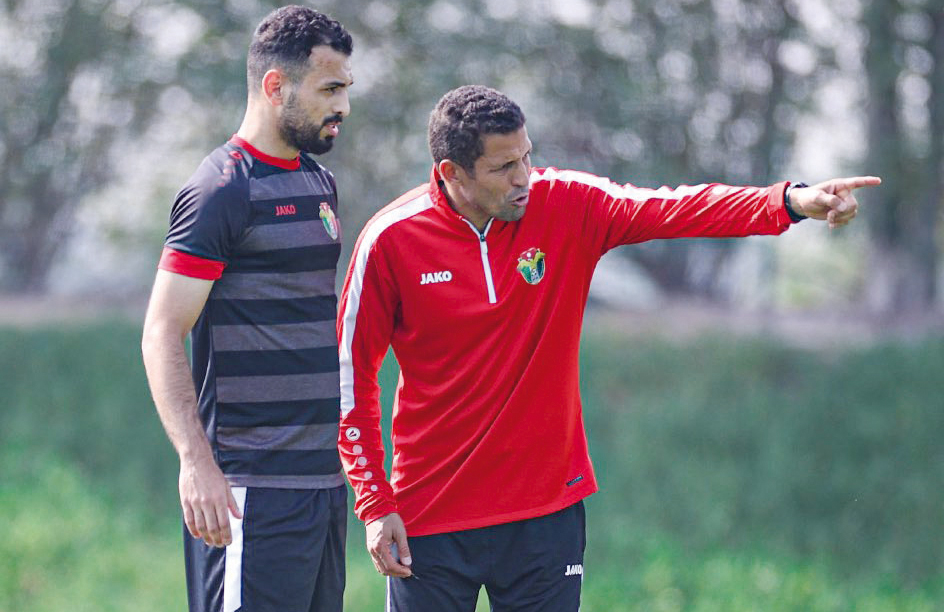 Jordan head coach Hussein Ammouta (right) with a player during a training session.