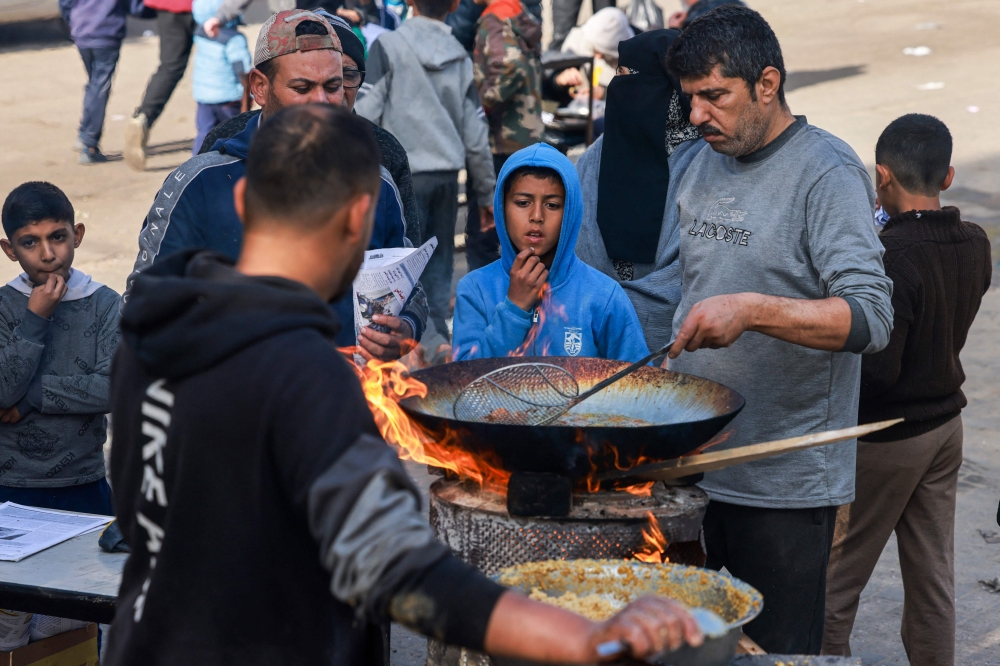 People prepare food in Rafah on the southern Gaza Strip on January 14, 2024. Photo by AFP