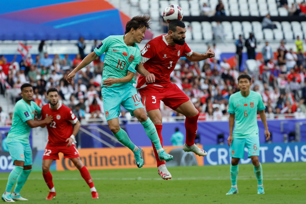 China's midfielder #10 Xie Pengfei fights for the header with Lebanon's defender #03 Maher Sabra during the Qatar 2023 AFC Asian Cup Group A football match between Lebanon and China at the Al-Thumama Stadium in Doha on January 17, 2024. (Photo by KARIM JAAFAR / AFP)
