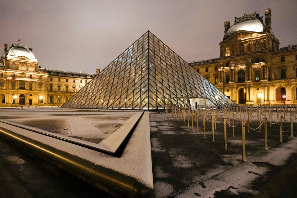 This photograph shows the snow-covered floor at the Louvre museum in Paris, with the Louvre Pyramid, designed by Chinese-American architect Ieoh Ming Pei, seen in the background, on January 18, 2024. (Photo by Dimitar DILKOFF / AFP)