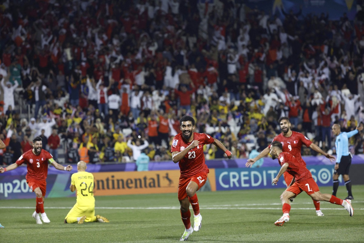 Bahrain’s defender Abdullah Al Khalasi celebrates after teammate Ali Madan (second right) scored a goal against Malaysia. AFP