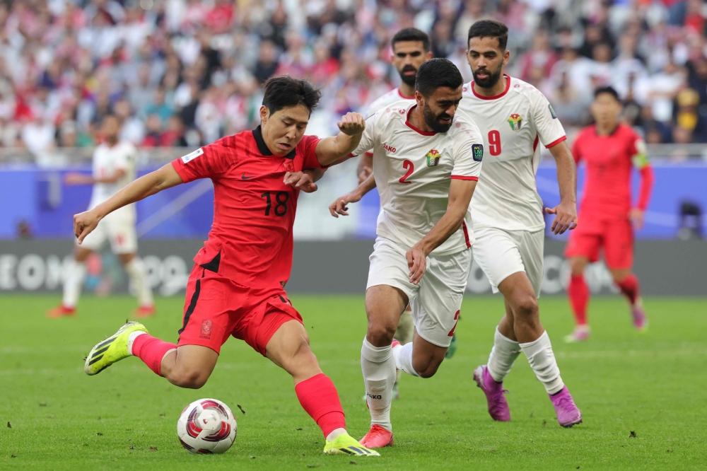 Jordan's defender #02 Mohammad Abu Hasheesh vies for the ball against South Korea's midfielder #18 Lee Kang-in during the Qatar 2023 AFC Asian Cup Group E football match between Jordan and South Korea at the Al-Thumama Stadium in Doha on January 20, 2024. (Photo by Giuseppe CACACE / AFP)