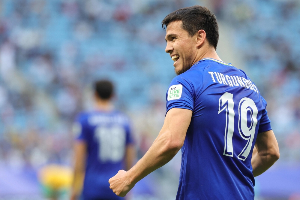 Uzbekistan's midfielder #19 Azizbek Turgunboev celebrates with teammates his team's first goal during the Qatar 2023 AFC Asian Cup Group B football match between Australia and Uzbekistan at the Al-Janoub Stadium in Al-Wakrah, south of Doha on January 23, 2024. (Photo by Giuseppe CACACE / AFP)