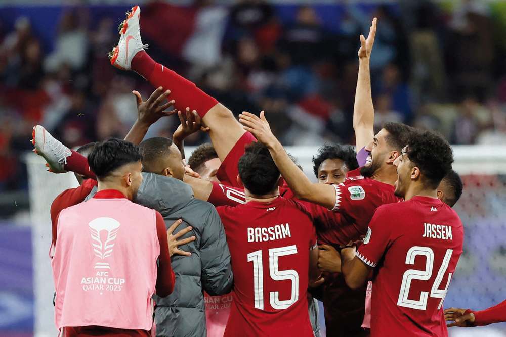 Qatar’s players toss their captain Hassan Al Haydos in the air. AFP