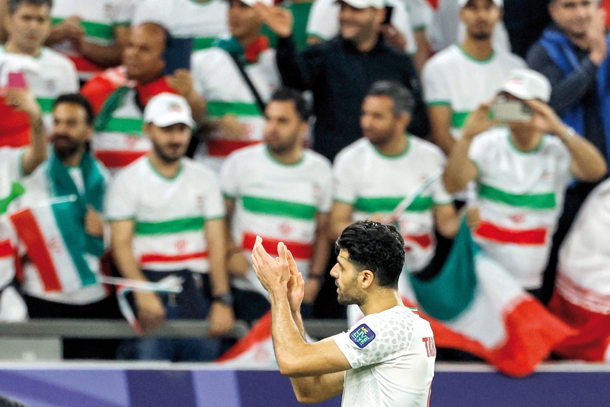 Iran’s forward Mehdi Taremi acknowledges supporters after win over  United Arab Emirates at Education City Stadium yesterday. AFP