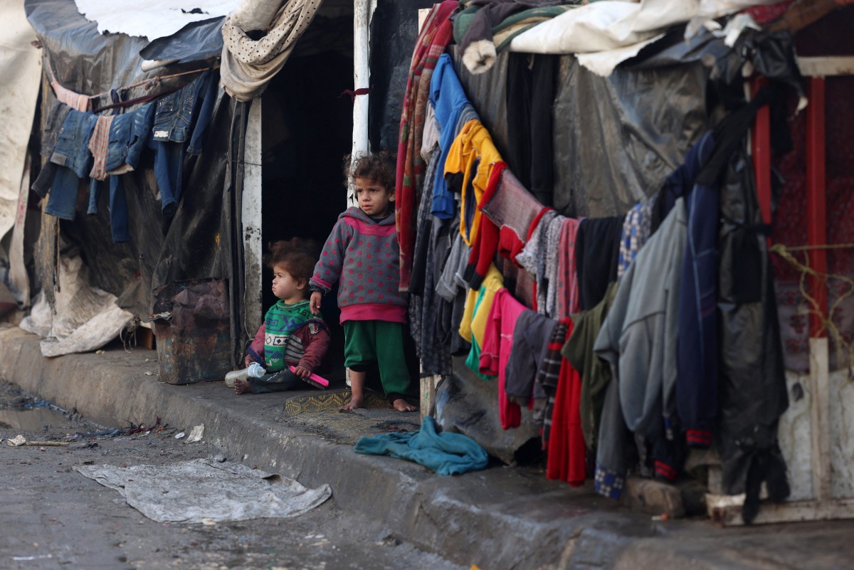 Children stand outside tents at a makeshift tent camp housing displaced Palestinians in Rafah near the border with Egypt in the southern Gaza Strip on January 23, 2024. Photo by AFP