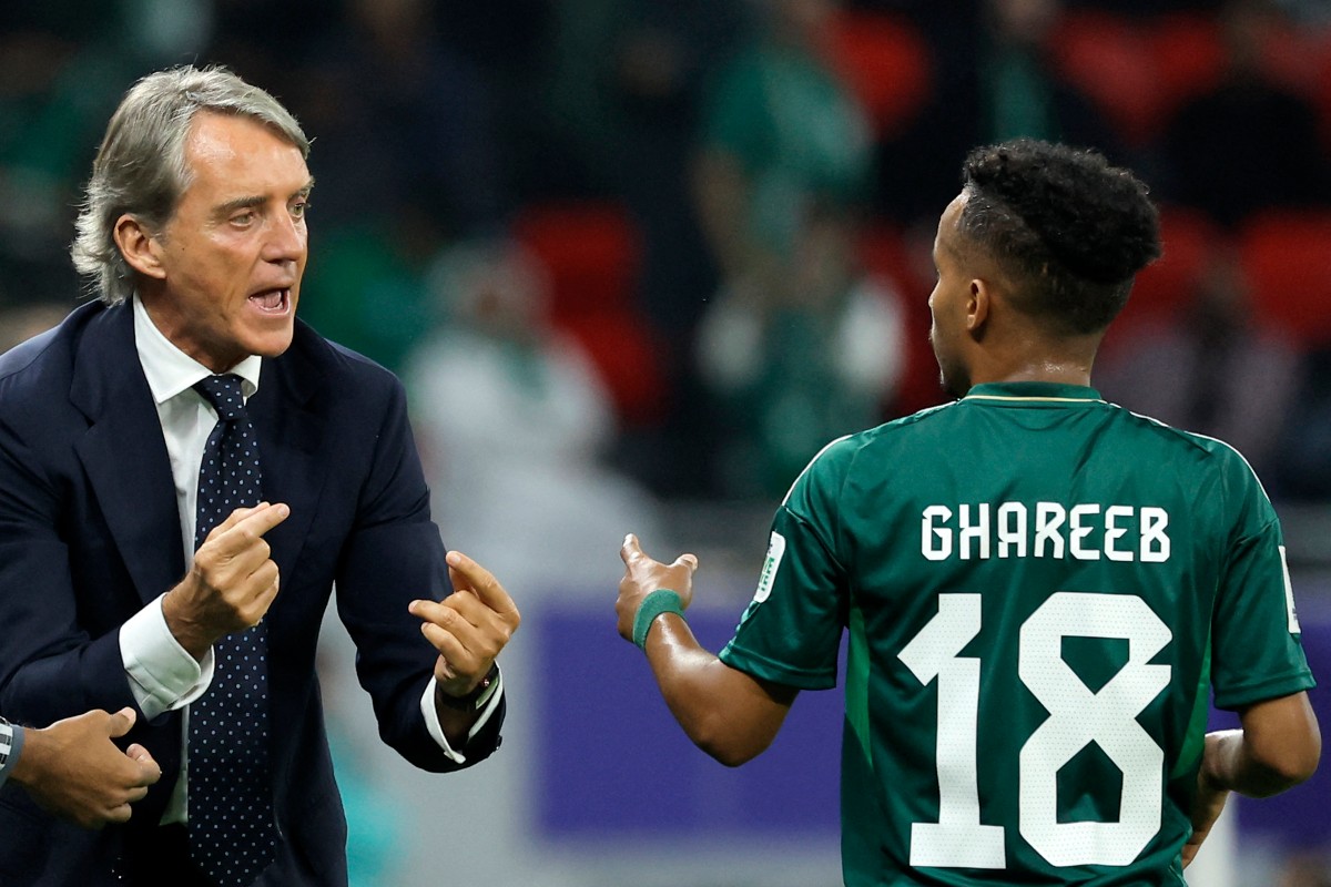 Saudi Arabia's Italian coach Roberto Mancini speaks with his midfielder #18 Abdulrahman Ghareeb during the Qatar 2023 AFC Asian Cup Group F football match between Kyrgyzstan and Saudi Arabia at the Ahmad Bin Ali Stadium in Al-Rayyan, west of Doha on January 21, 2024. (Photo by KARIM JAAFAR / AFP)