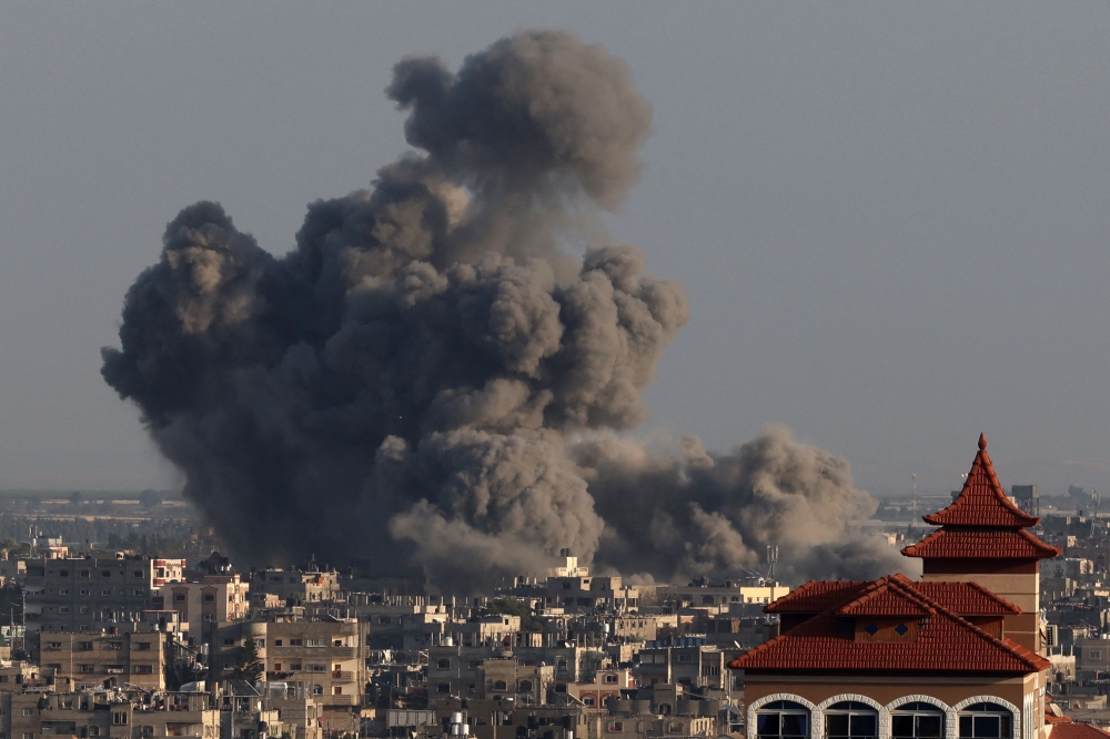 A picture taken from Rafah shows smoke billowing over Khan Yunis in the southern Gaza Strip during Israeli bombardment on January 24, 2024. (Photo by AFP)