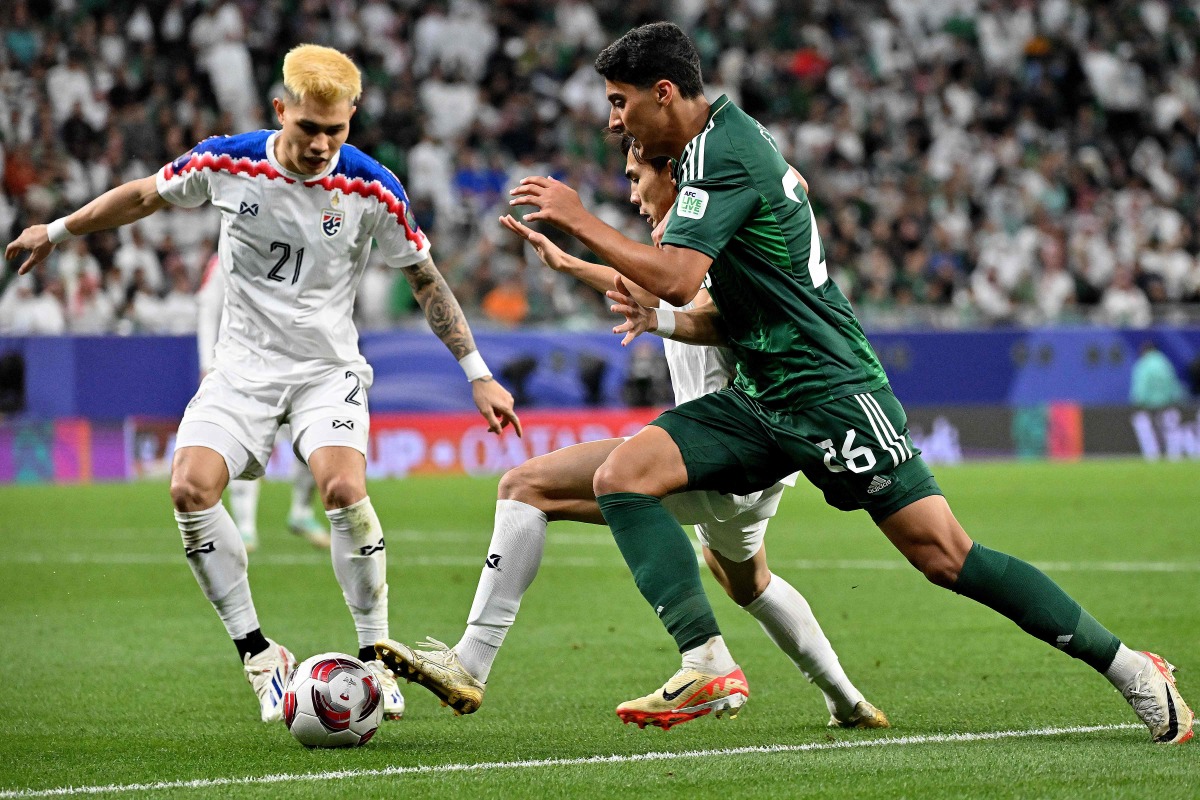 Saudi Arabia’s Faisal Al Ghamdi (right) fights for the ball with two Thailand players. AFP