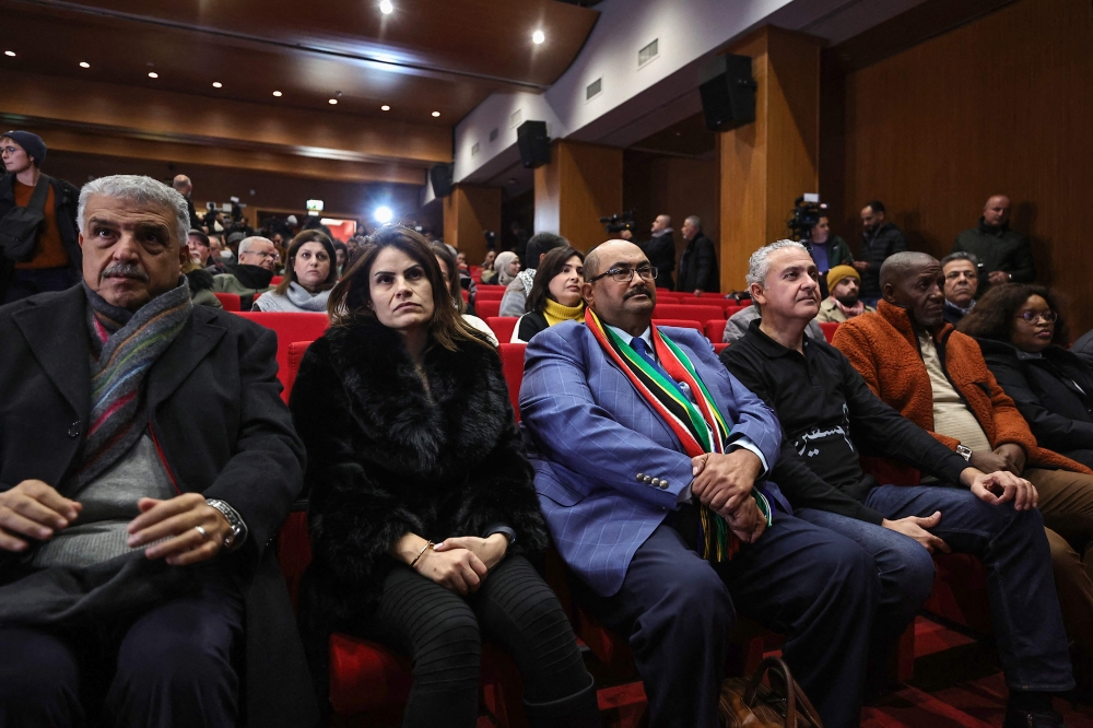 South Africa's Ambassador to Palestine Shaun Byneveldt (3L) attends with Palestinians a live projection of the International Court of Justice (ICJ) hearing of the case brought by his country against Israel, at the Ramallah municipality in the occupied West Bank on January 26, 2024. (Photo by Zain JAAFAR / AFP)
