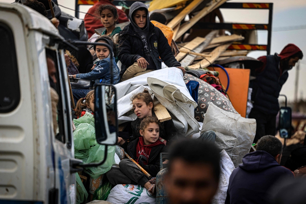 Palestinians carry some belongings as they flee Khan Yunis in the southern Gaza Strip on January 26, 2024. Photo by AFP