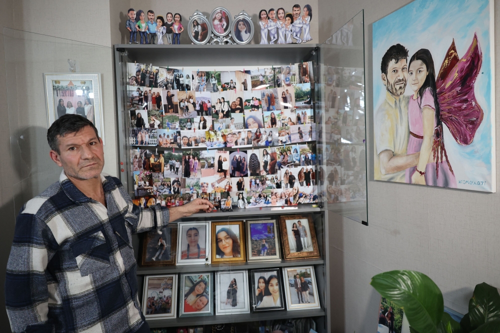 Mesut Hancer, stands infront of photographs of his 15-year-old-daughter Irmak, on February 6, 2023, during an interview in Ankara on January 11, 2024. (Photo by Adem Altan / AFP)