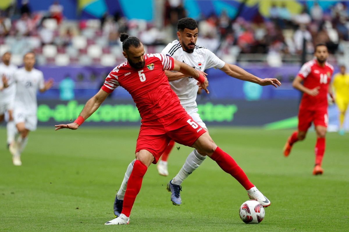 Iraq's forward #18 Aymen Hussein fights for the ball with Jordan's defender #05 Yazan al-Arab during the match between Iraq and Jordan at Khalifa International Stadium in Doha on January 29, 2024. (Photo by KARIM JAAFAR / AFP)
