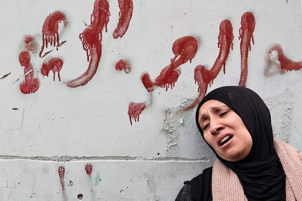 The mother of Muhammad Ayman Ghazawi and Basel Ayman Ghazawi, two of three Palestinian men killed by undercover Israeli agents mourns during their funeral in the occupied West Bank city on January 30, 2024. (Photo by Zain Jaafar / AFP)