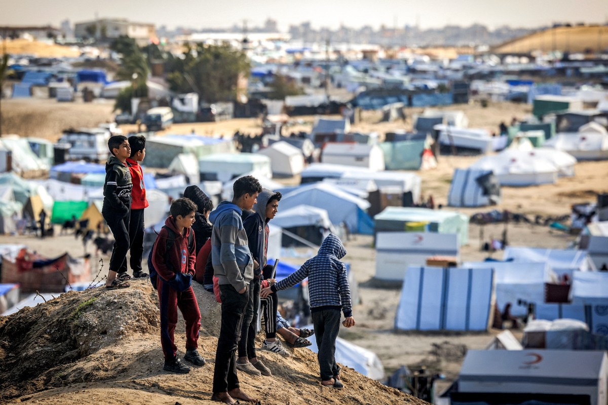 Children stand atop a small hill near tents at a make-shift shelter for Palestinians who fled to Rafah in the southern Gaza Strip on January 30, 2024. 