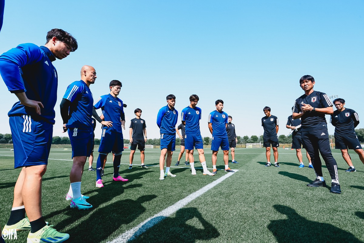 Japan coach Hajime Moriyasu speaks to his players during a training session.