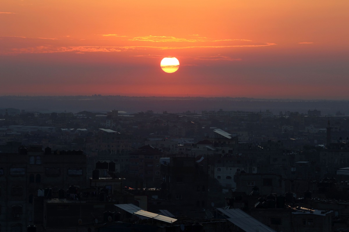 The sun rises over Rafah in the southern Gaza Strip on February 3, 2024 (Photo by SAID KHATIB / AFP)

