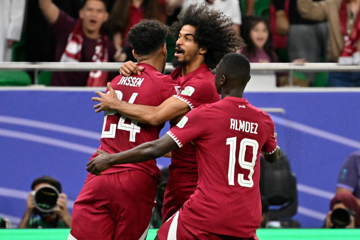 Jassem Gaber (left) celebrates with teammates Akram Afif and Almoez Ali after scoring Qatar’s first goal against Iran. AFP