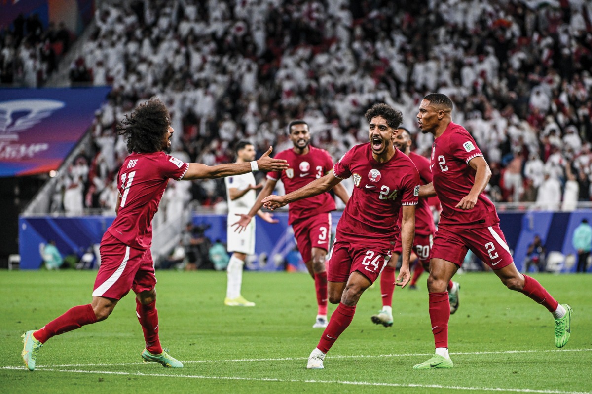 Jassem Gaber celebrates with teammates after scoring Qatar’s first goal against Iran. 