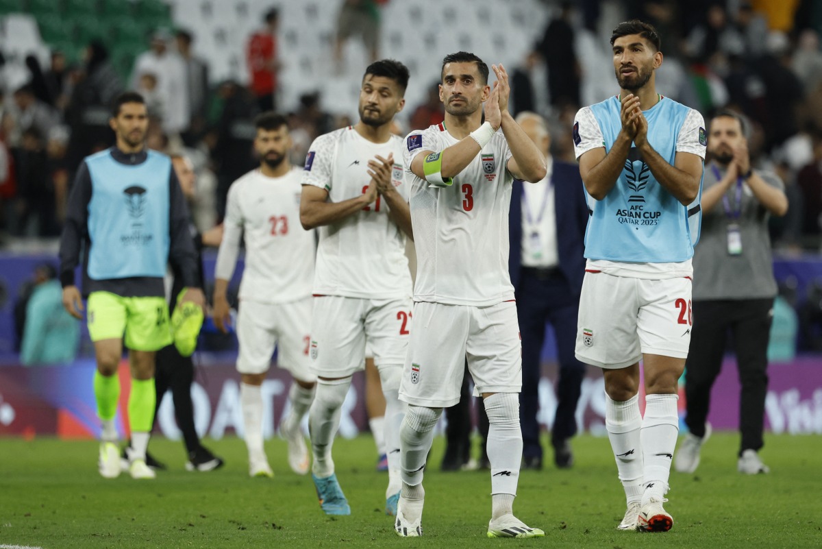 Iran’s Ehsan Hajsafi (centre) and teammates salute the spectators. AFP