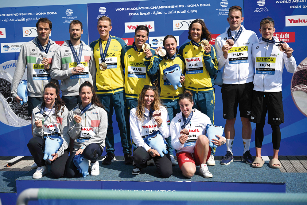 Silver-medallists team Italy, gold-medallists team Australia and bronze-medallists team Hungary pose on the podium with their medals after the final of the mixed 4X1500m relay open water swimming event. PICS: AFP