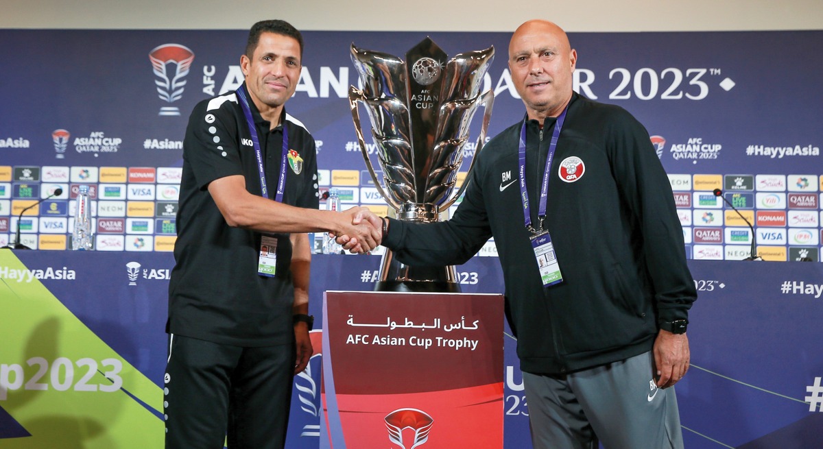 Jordan coach Hussein Ammouta and Qatar coach Marquez Lopez shake hands following a press conference, yesterday.