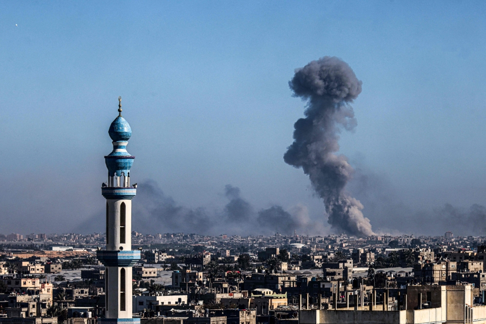 A picture taken from Rafah shows smoke billowing during Israeli bombardment over Khan Yunis in the southern Gaza Strip on February 11, 2024. (Photo by Said Khatib / AFP)