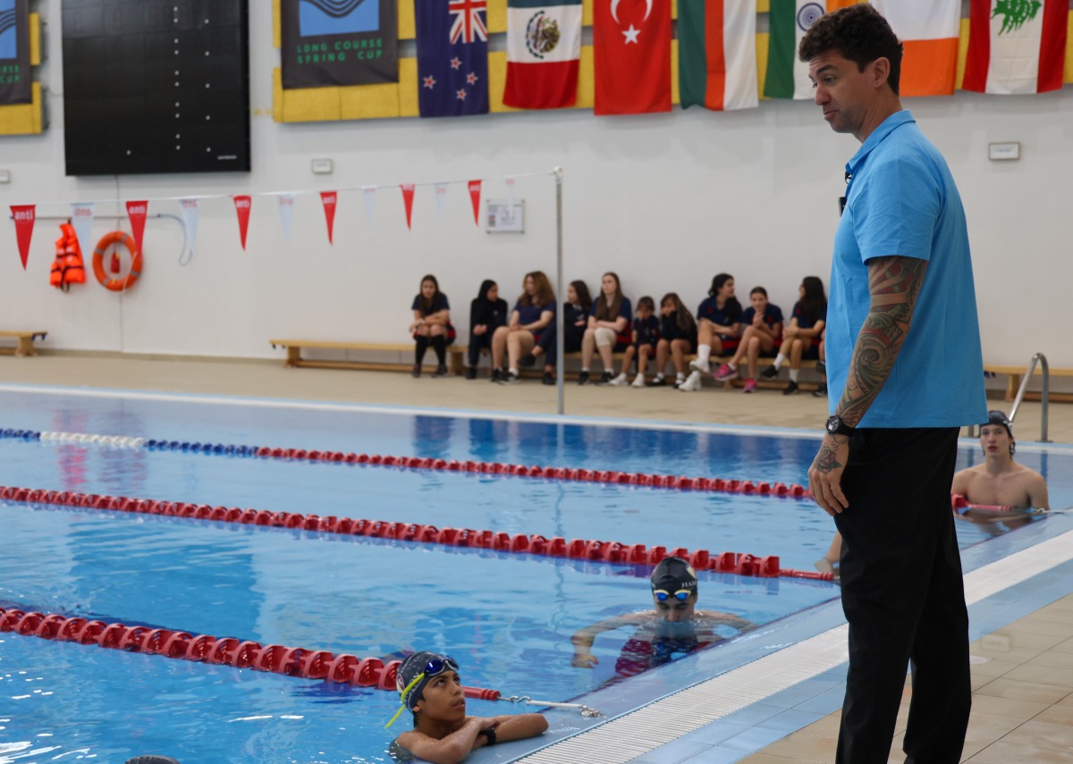 Doha 2024 ambassador Anthony Ervin speaks with young swimmers. 