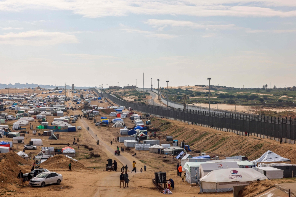 Displaced Palestinians camp near the border fence between Gaza and Egypt, on February 16, 2024 in Rafah, in the southern Gaza Strip. (Photo by Mohammed Abed / AFP)