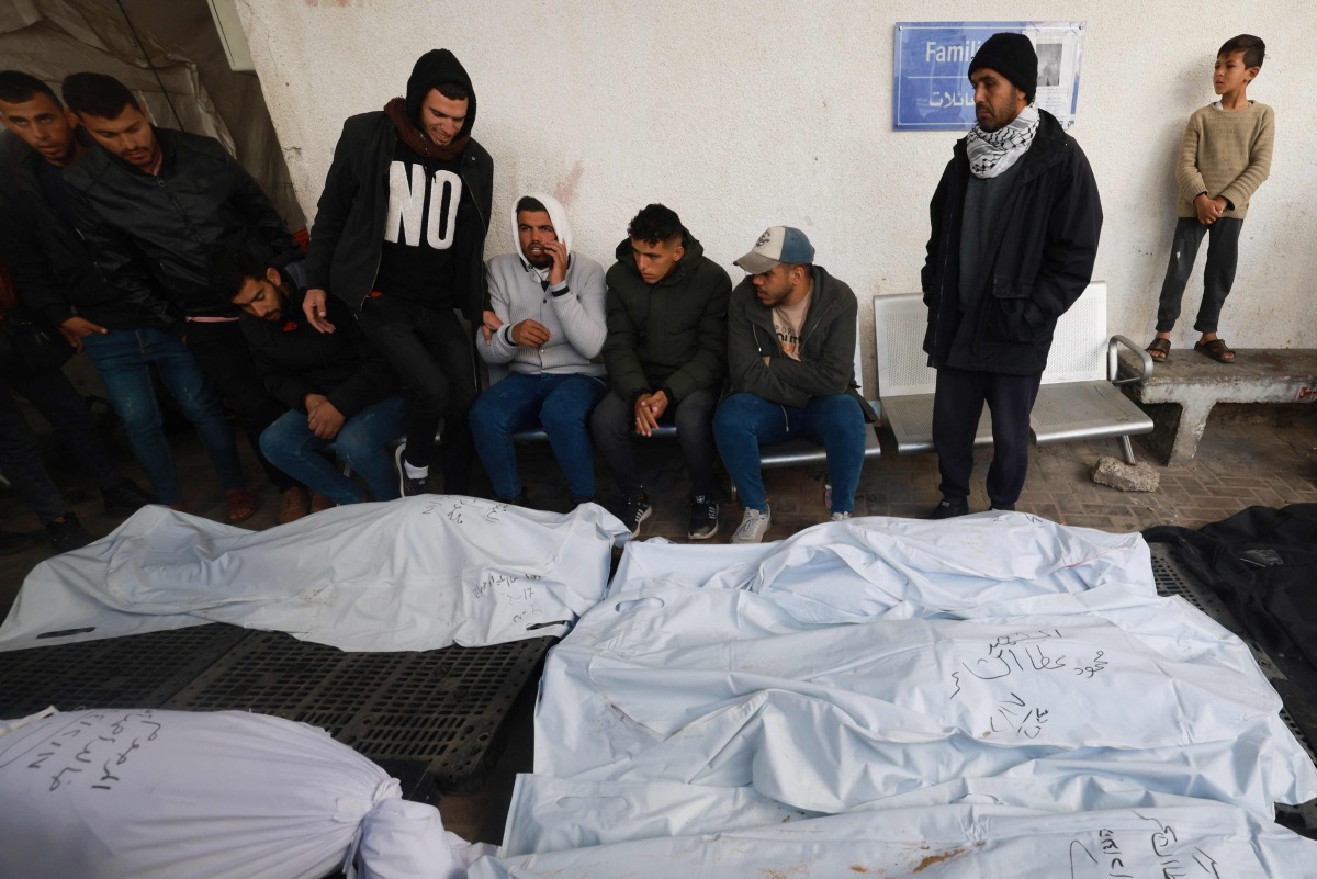 Palestinians gather to identify the bodies of relatives Rafah's Al-Najjar hospital on February 18, 2024, following overnight Israeli air strikes on the southern Gaza Strip.